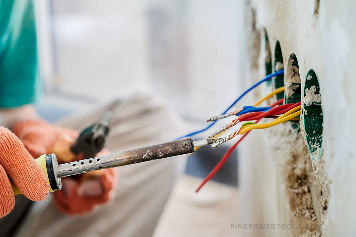Electrician working with heater soldering iron.