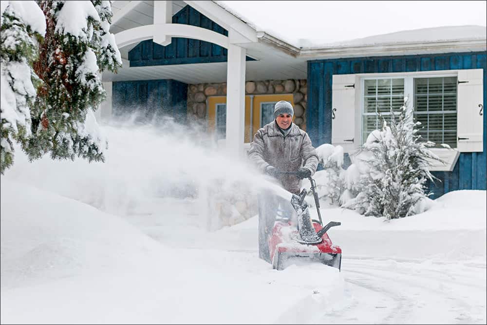 Man clearing driveway with snowblower